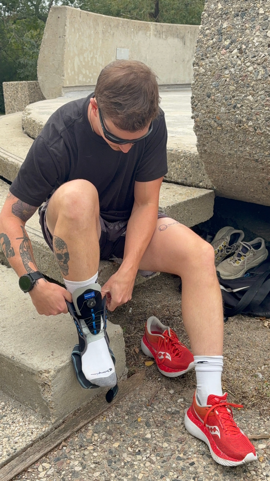 Athlete fastening his ankle brace before a run in the park