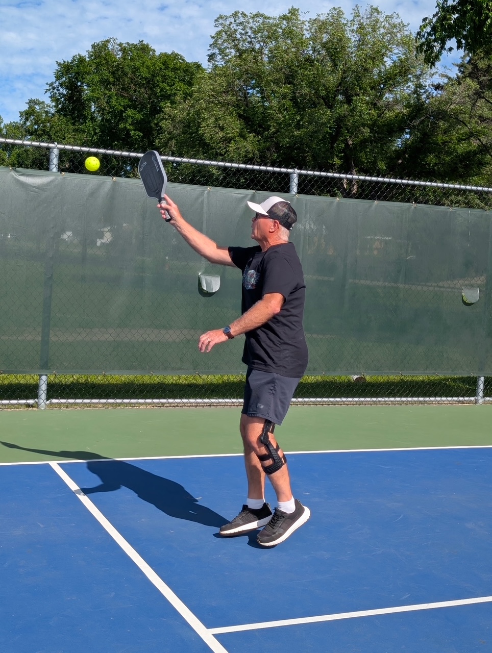 Pickleball player serving on an outdoor court